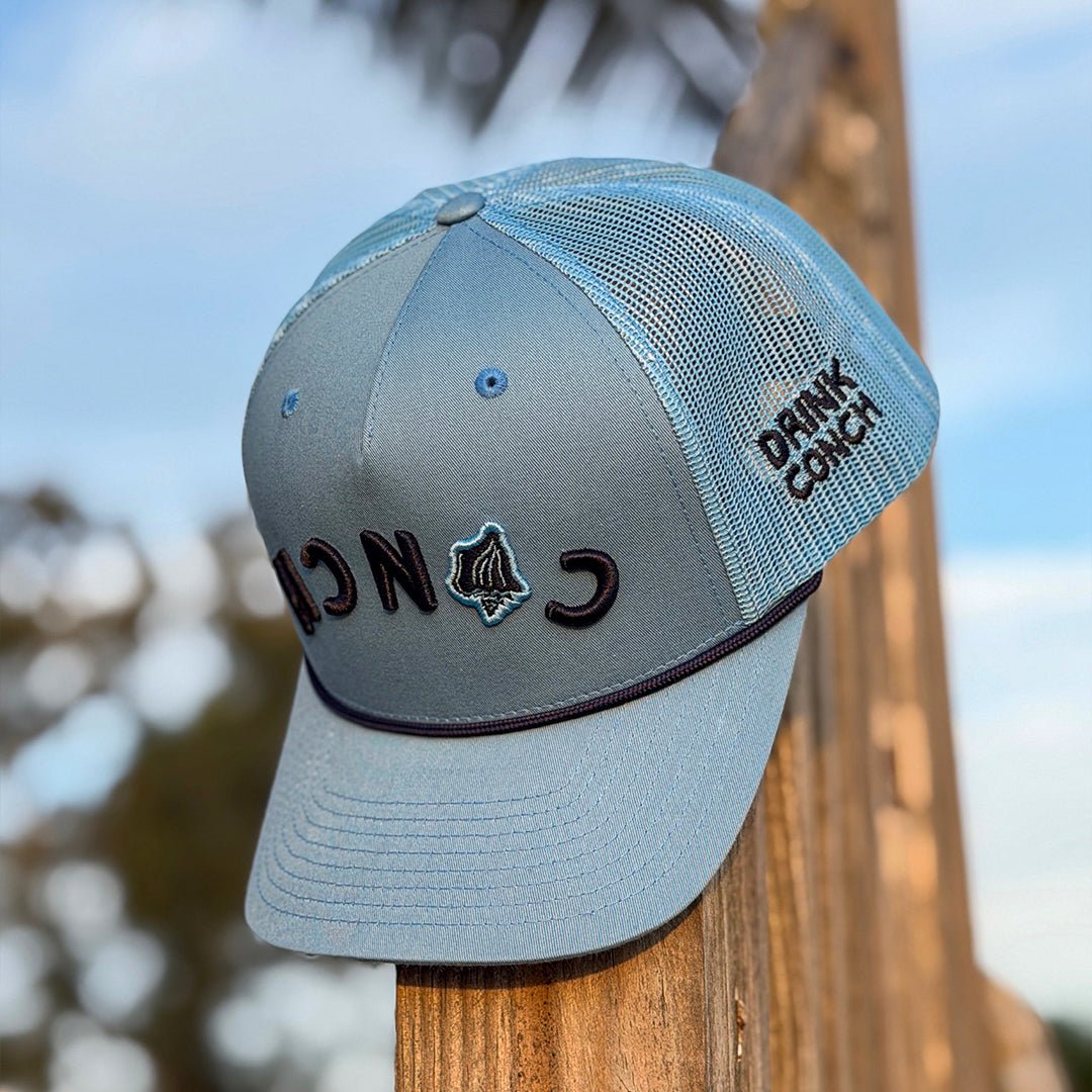 Drink Conch Calypso hat sitting on wooden post