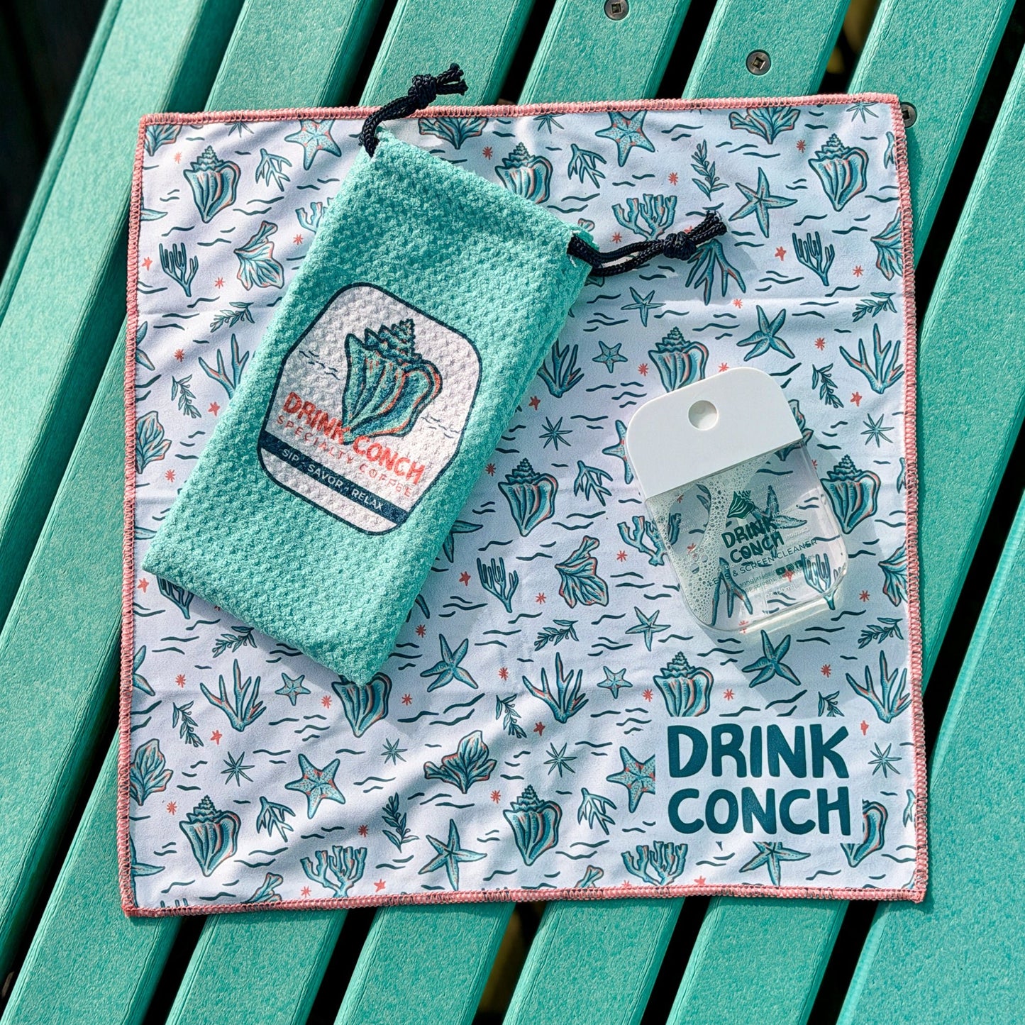 Sunglass and screen cleaning kit sitting on  a teal bench